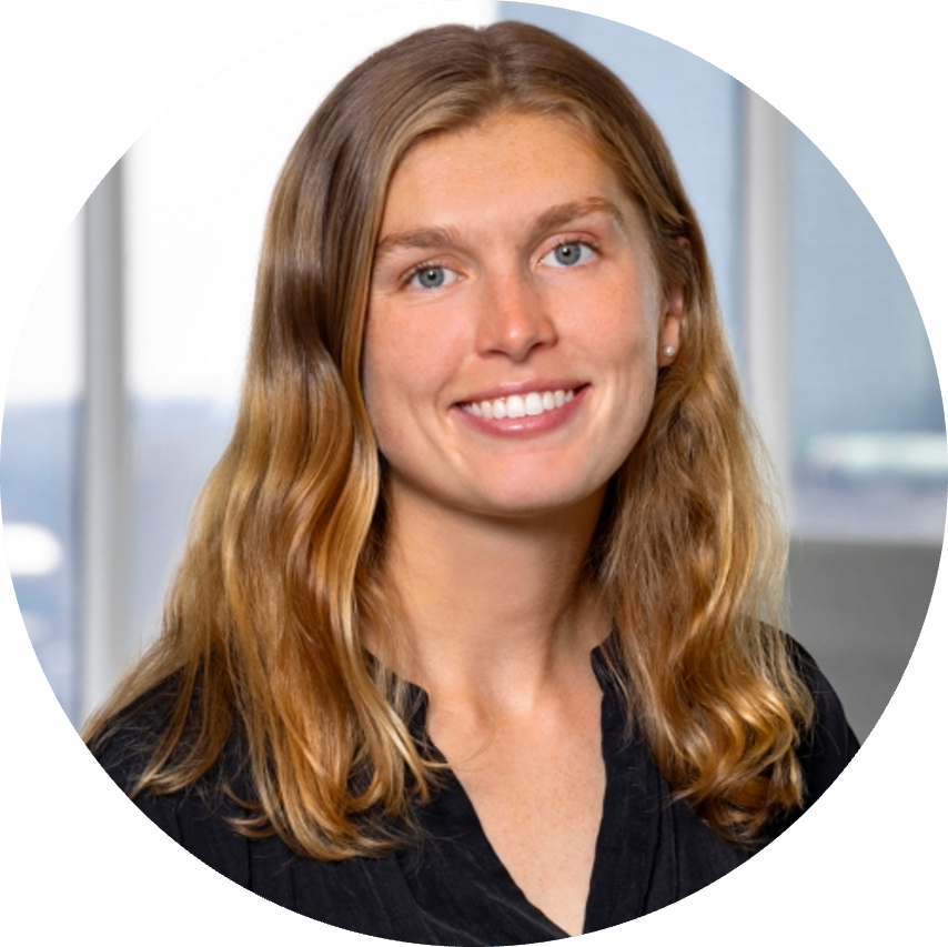Smiling woman with long wavy brown hair and blue eyes. Professional headshot.