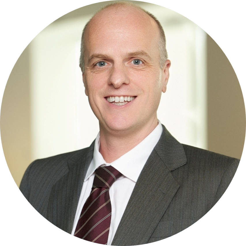 Smiling bald man in a suit and striped tie.